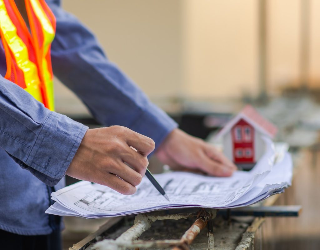 Un ouvrier du bâtiment prenant des note sur un chantier