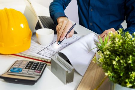 Un chef de chantier qui travaille à son bureau, analysant des plans de travaux