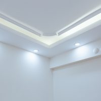 Un plafond blanc avec ampoules à LED et néon incorporés