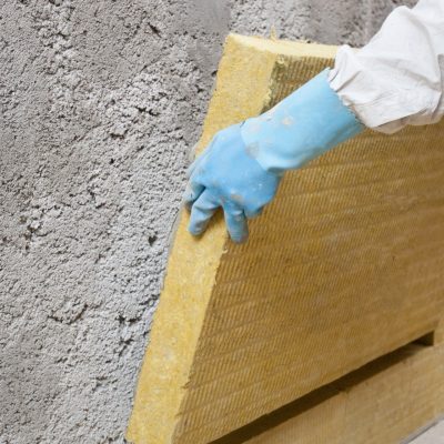 Un homme en train de travailler à l'isolation d'un mur
